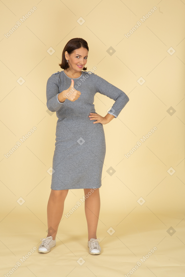 身振りで示す灰色のドレスを着た女性の正面図
