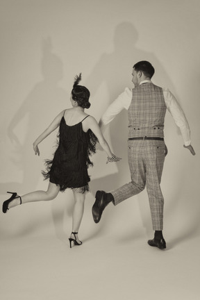 Man and woman dancing charleston back to camera