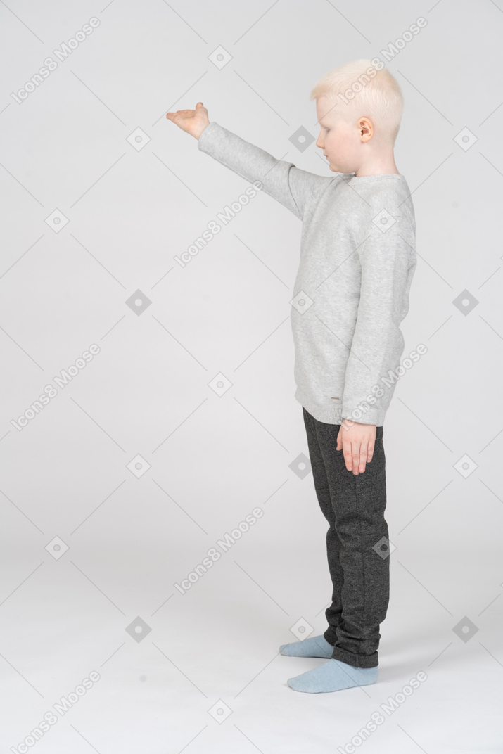 Boy pointing to the side with raised hand