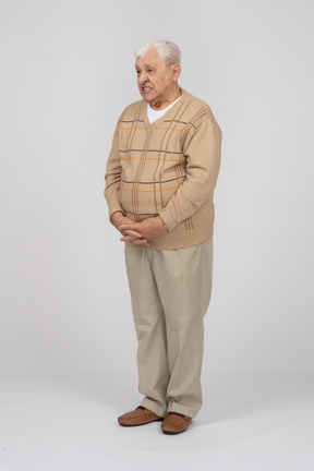 Front view of an old man in casual clothes making faces