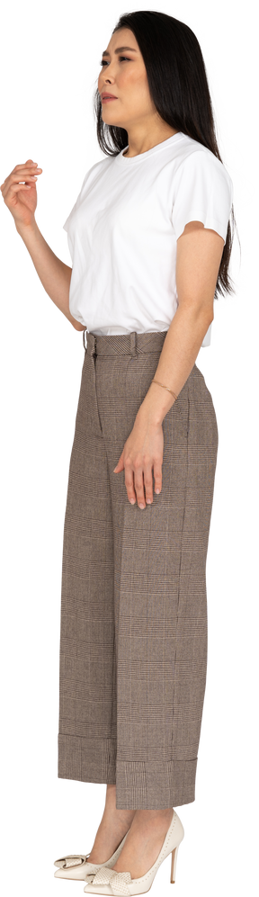 Vista lateral de una señorita estornudando en calzones y camiseta levantando la mano