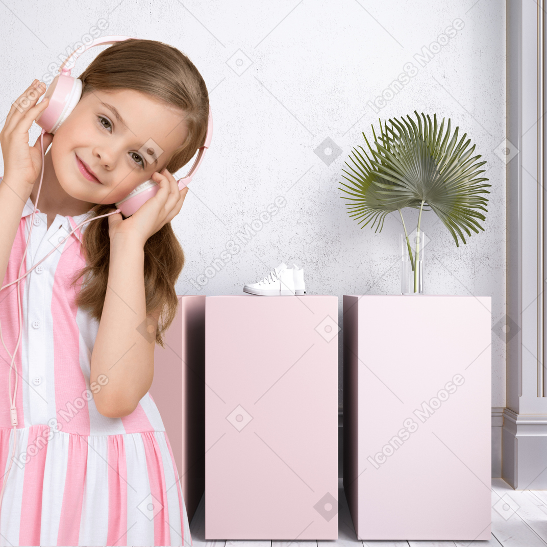 A little girl in a pink dress listening to headphones