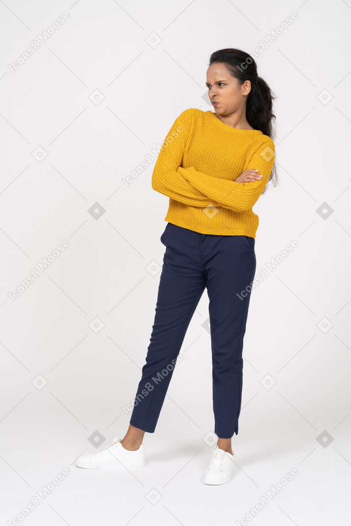 Front view of a girl in casual clothes posing with crossed arms and making faces
