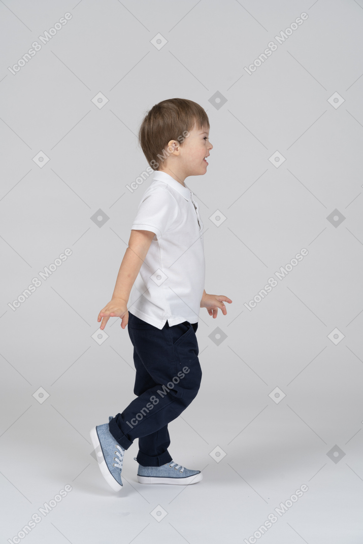Side view of a little boy walking