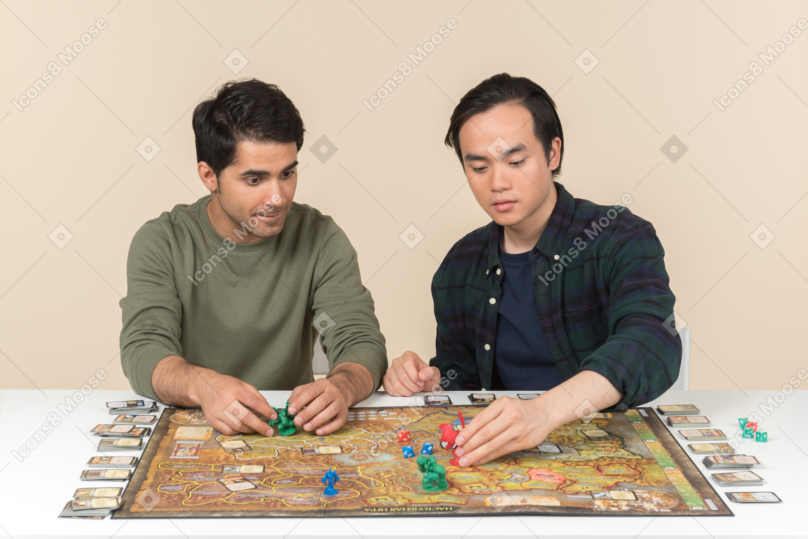 Amici maschi interrazziali seduti al tavolo e giocando a gioco da tavolo