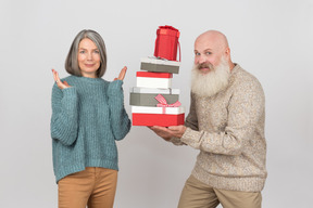 Aged man giving gifts to an elegant mature woman