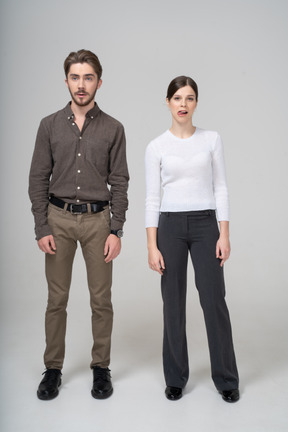 Vista frontale di una giovane coppia in abiti da ufficio che mostra la lingua