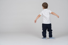 Back view of little boy swinging his arms