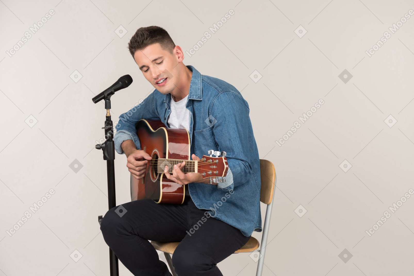 Young stand-up comic playing on guitar and singing in microphone