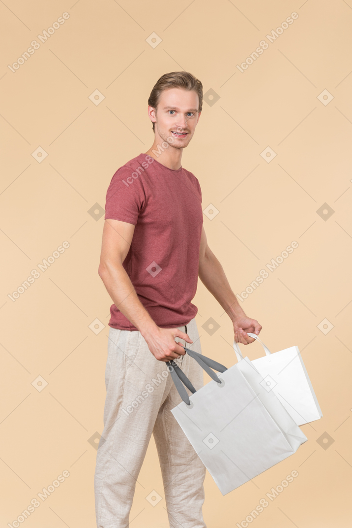 Young guy holding white shopping bags