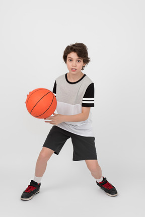 El chico esta listo para pasar la pelota de baloncesto