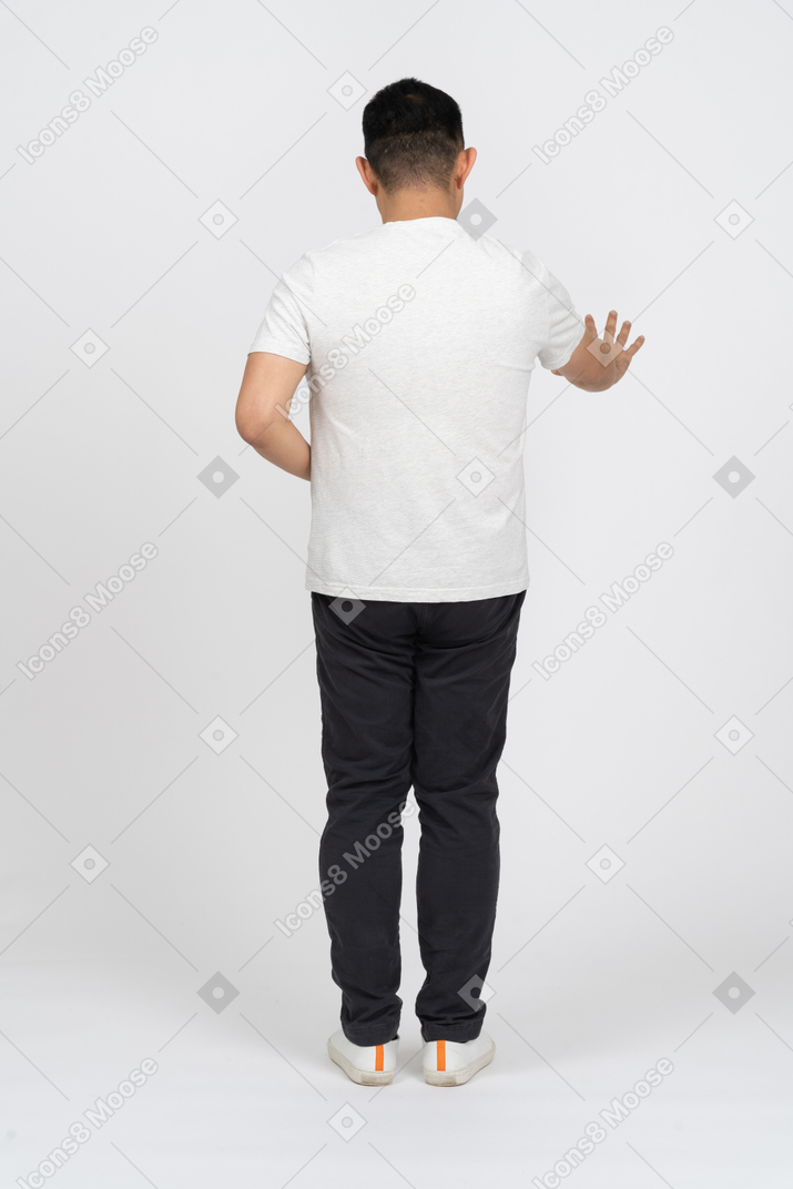 Rear view of a man in casual clothes showing stop gesture