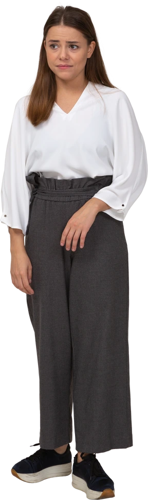 Front view of an upset young lady in office clothing looking aside