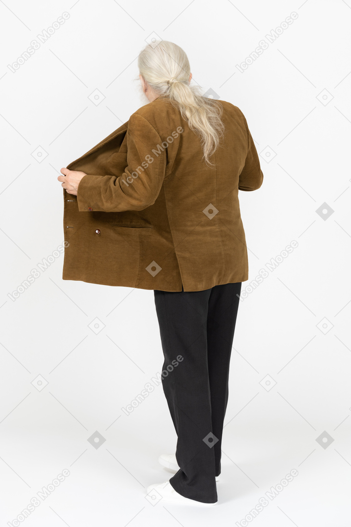 Vista posteriore di un uomo dai capelli grigi che apre la giacca