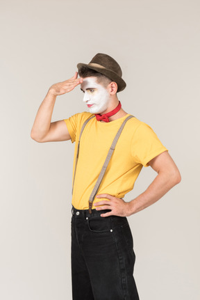 Male clown standing half sideways and closing hid face with hand
