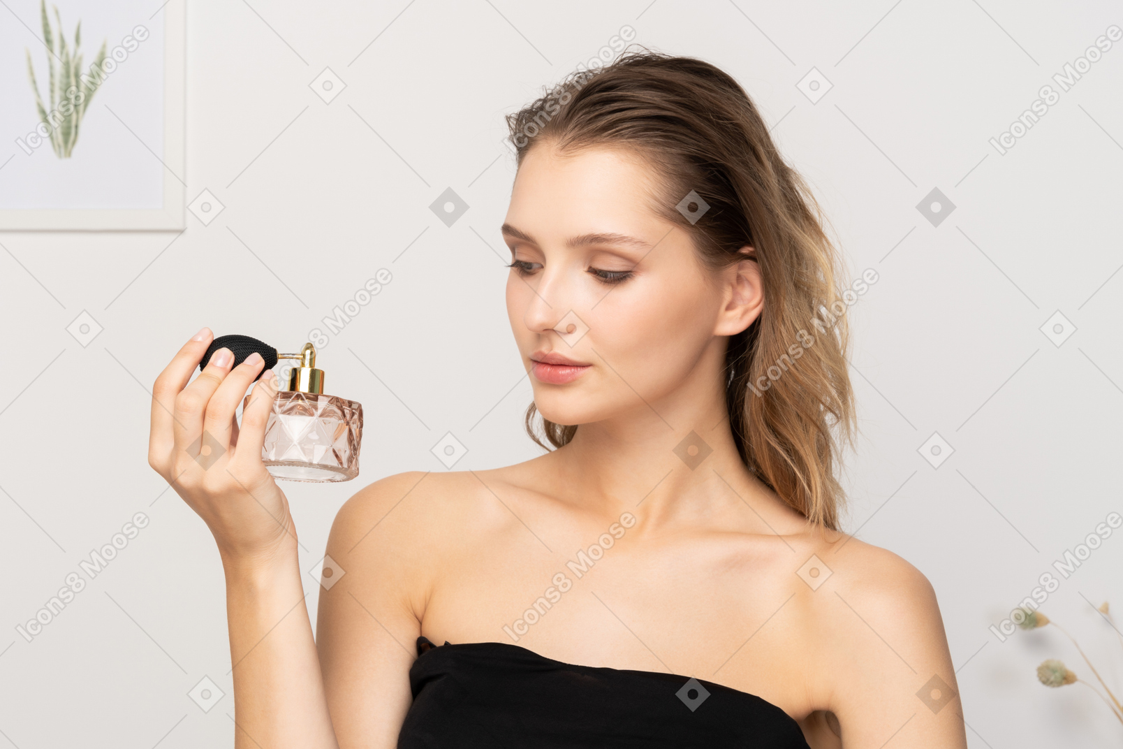 Vista frontale di una giovane donna sensuale con in mano una bottiglia di profumo