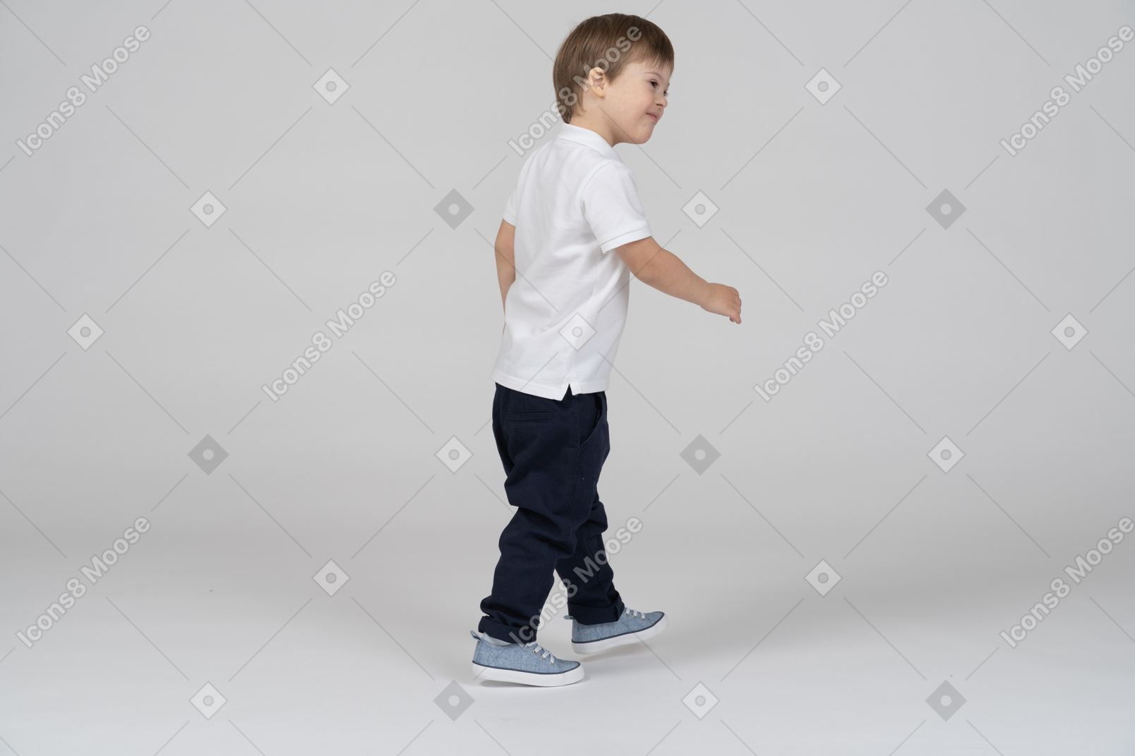 Vista traseira de três quartos de um menino andando e sorrindo
