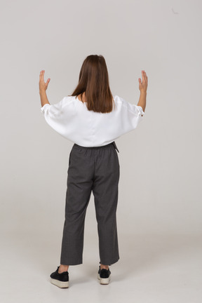Vista posterior de una joven en ropa de oficina que muestra el tamaño de algo