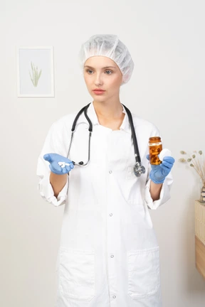 Vista frontal de una joven doctora sosteniendo pastillas