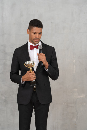 A man in a tuxedo holding a microphone