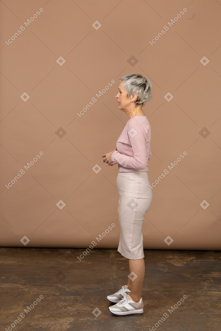 プロフィールに立っているカジュアルな服装で動揺した女性