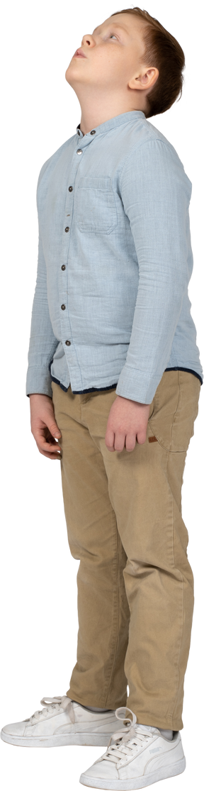 見上げるカジュアルな服装の少年の側面図