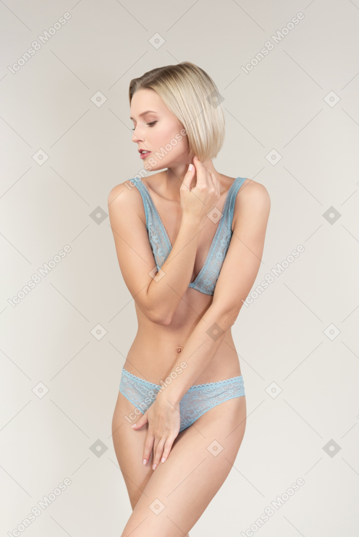 Sexy mujer joven en ropa interior cubriéndose con los brazos