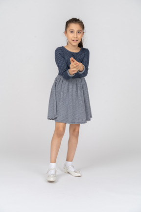 Front view of a girl making a finger gun with a smile