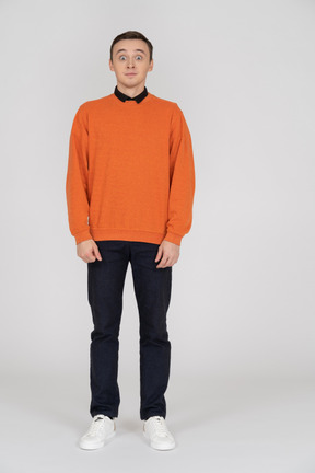 Junger mann im orangefarbenen sweatshirt stehend