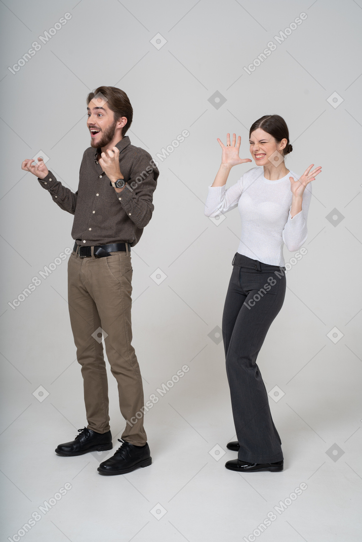 Three-quarter view of a delighted young couple in office clothing
