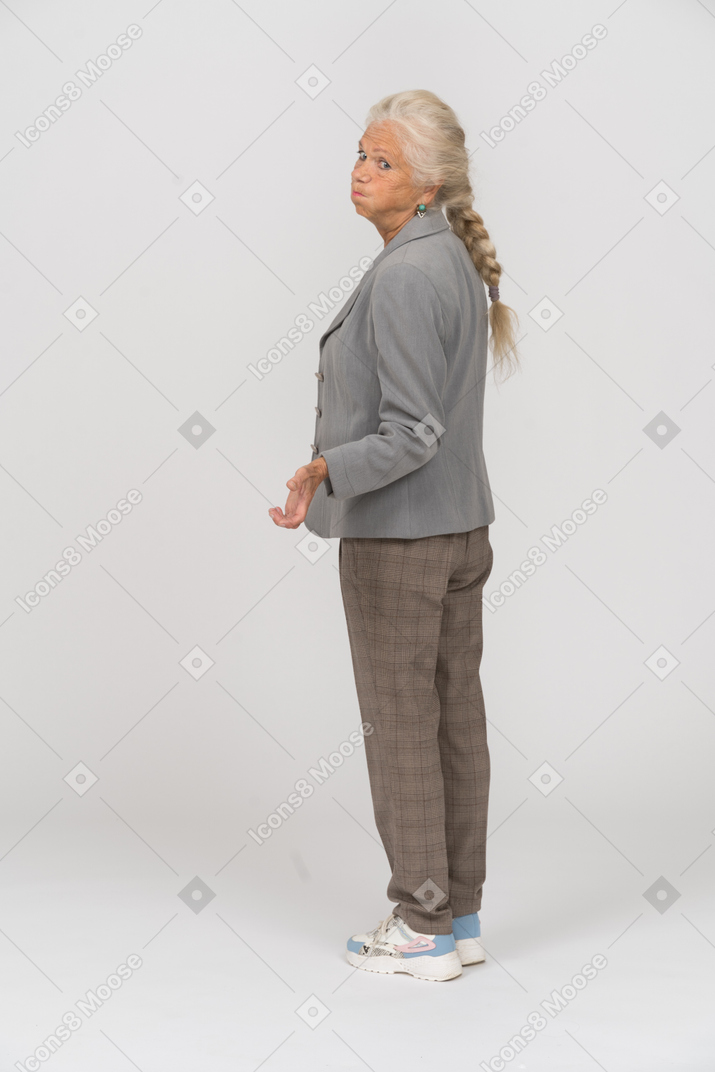 Anciana en traje posando de perfil y haciendo muecas