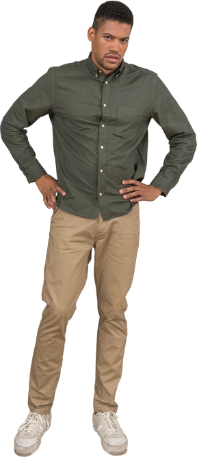 Front view of a man frowning grudgingly with hands on his hips