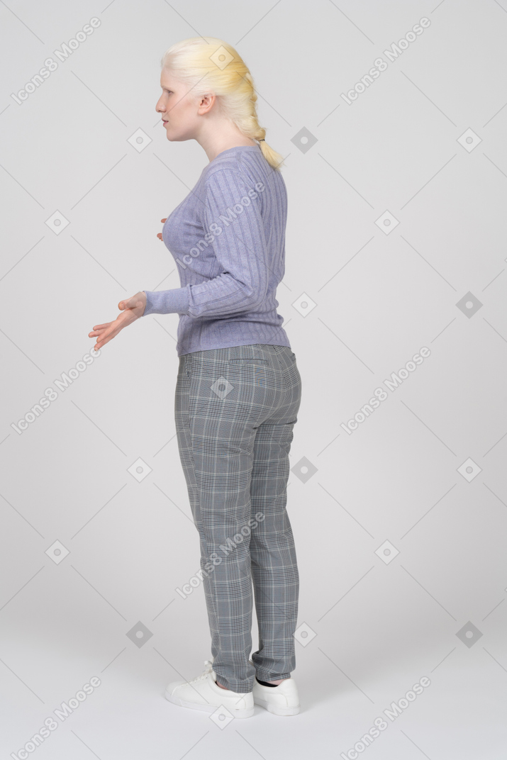 Rear view of young woman shrugging