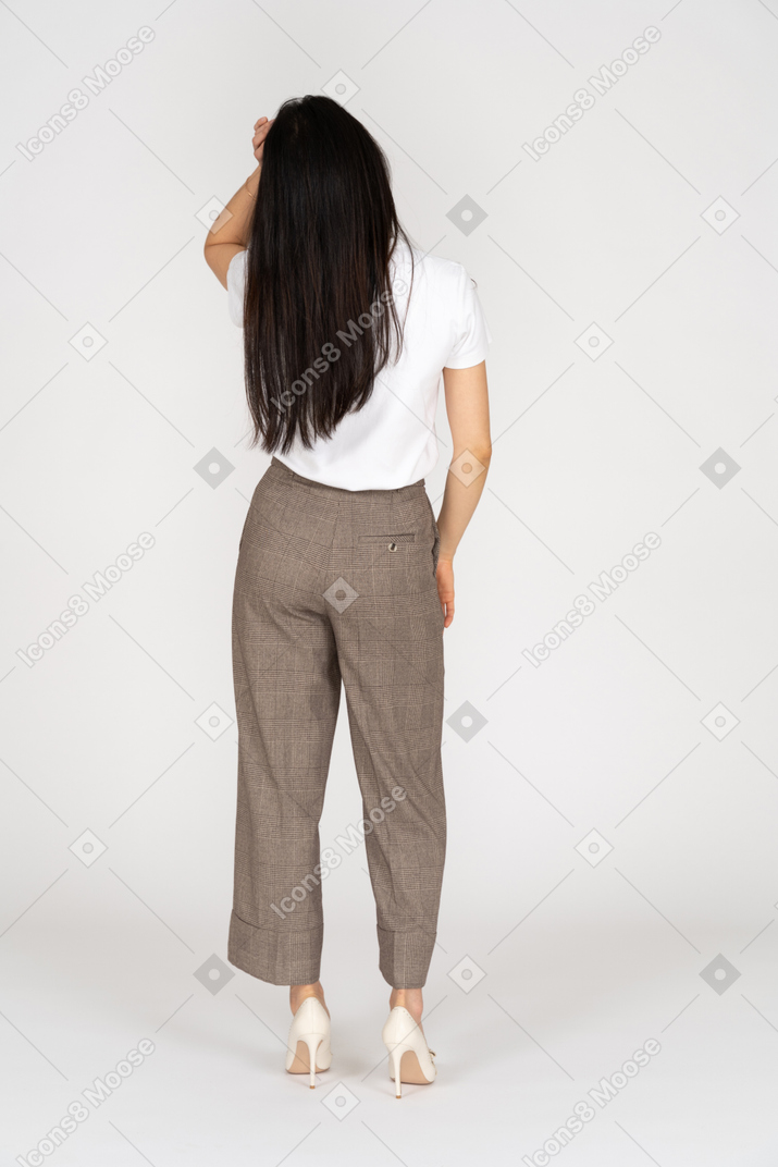 一位年轻的女士，穿着马裤和t恤抚摸她的头后面观