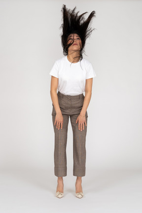 Vista frontal de uma jovem de calça e camiseta com cabelo bagunçado