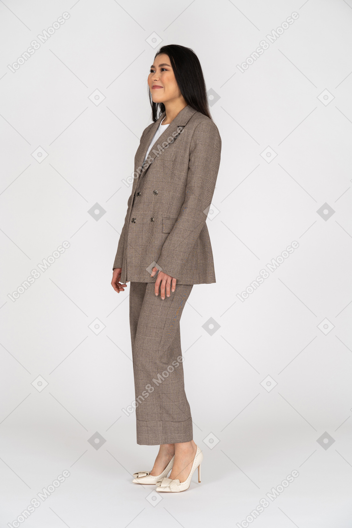 茶色のビジネススーツを着た若い女性の4分の3のビュー