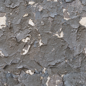 Muro de piedra cubierto por una capa de pintura vieja