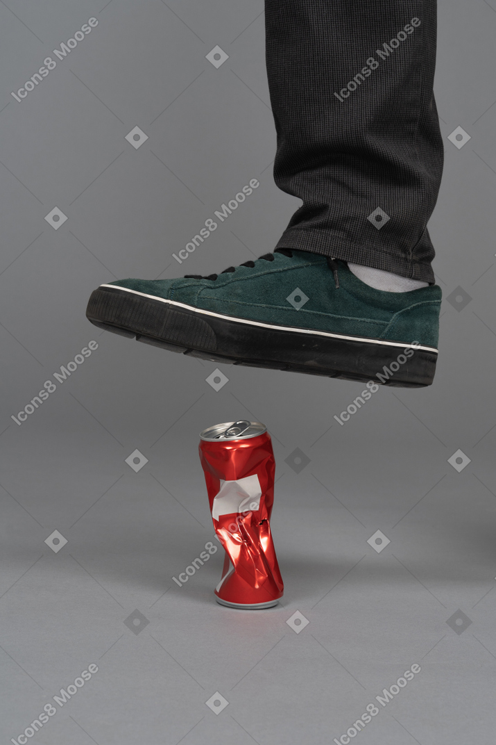 Foot stepping on cola can