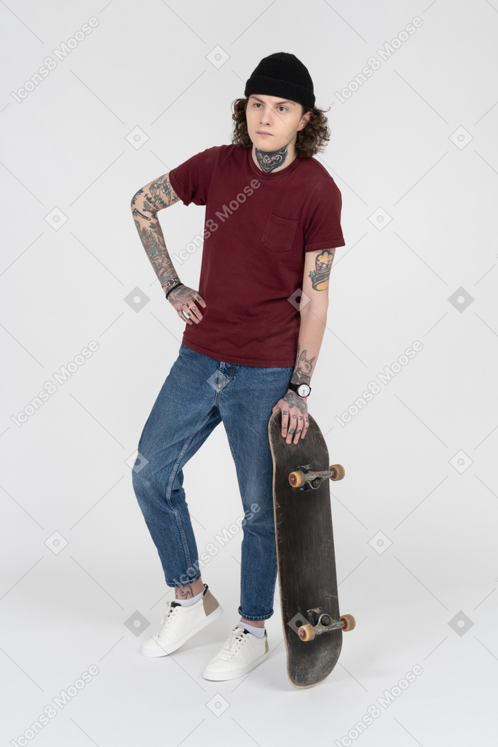 A teenager standing with his skateboard