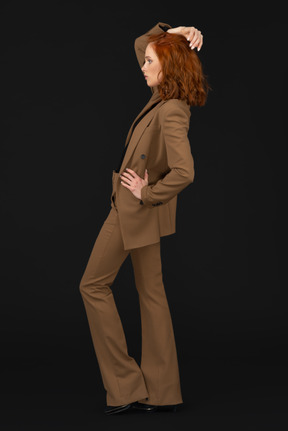 Side view of posing woman in brown suit