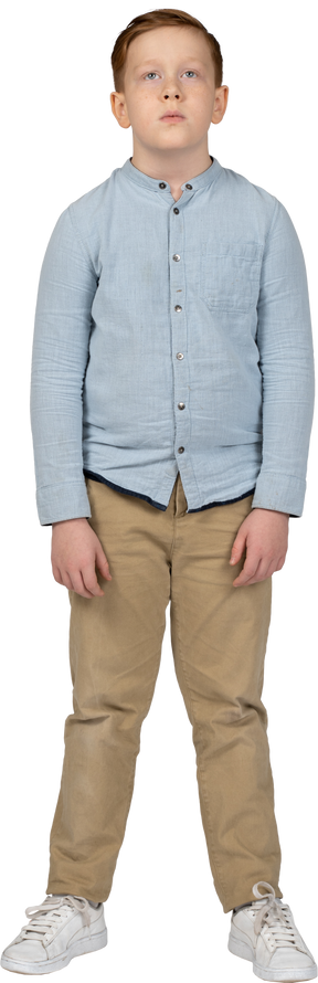 Vista frontal de un niño con ropa informal mirando hacia arriba