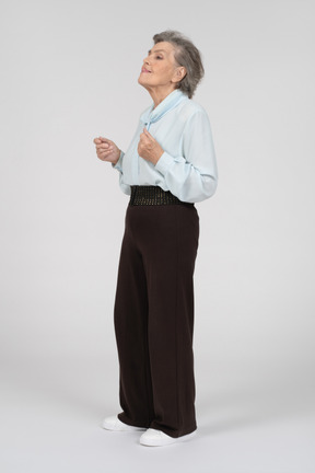 Side view of an old woman touching nose with her tongue