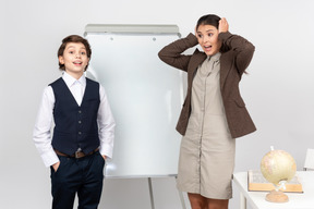 Dazed young teacher and a pupil answering in class