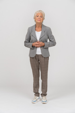Front view of a sad old lady in suit looking at camera