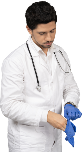 Médico calçando luvas azuis