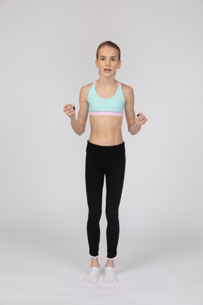 Side view of a teen girl in sportswear raising hand and arguing