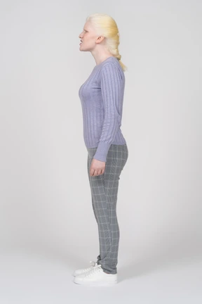 Side view of a woman standing with arms at sides