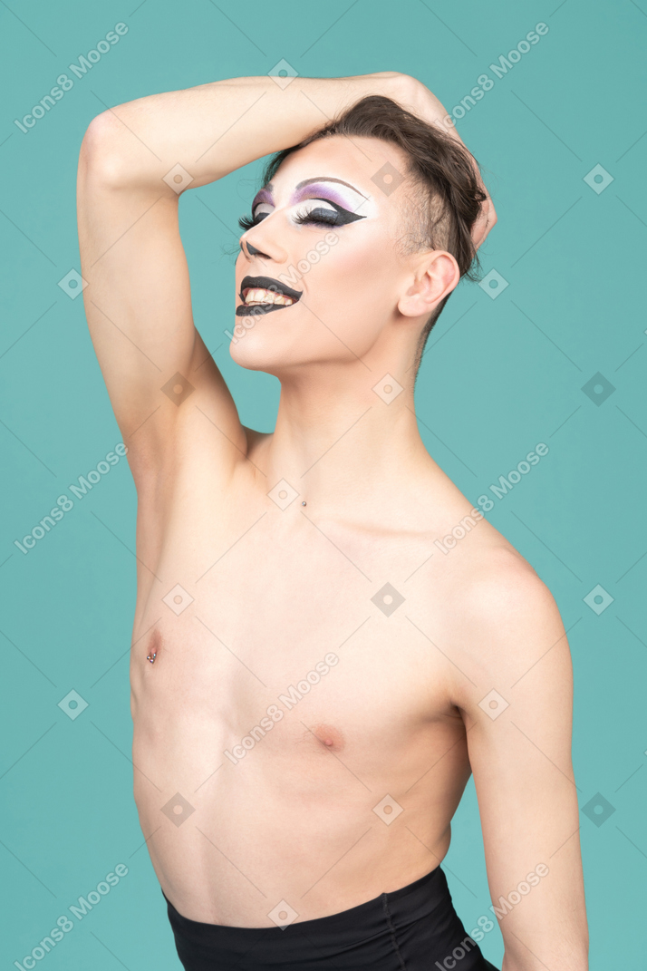 Drag queen resting hand on top of head and smiling