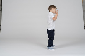 Vista lateral de um menino espalhando os dedos