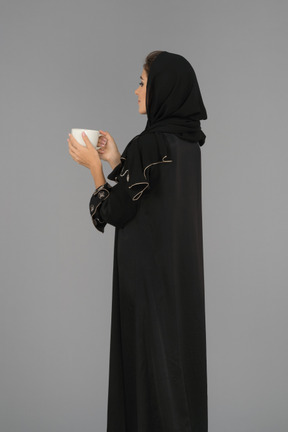 Young muslim woman holding a cup